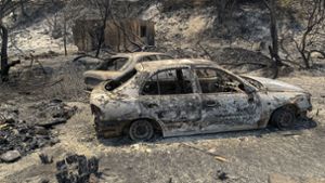 Die Waldbrände in Griechenland hinterlassen( Bild: verbrannte Autowracks stehen  auf einer Straße der griechischen Insel Rhodos) Schneisen der Verwüstung. Foto: L/fteris Damianidis/InTime News/AP/dpa