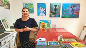 Tania Lindner betreut für die Caritas das Projekt der  Galerie Sichtbar. Im Arbeitsraum  steht die ausgebildete  Künstlerin vor Gemälden, auf denen  häufig herausfordernde Biografien in faszinierenden Kunstwelten verarbeitet werden. Foto: /ak