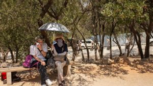 Touristen unter Bäumen am Eingang der Akropolis im Hitzesommer 2023. Foto: Socrates Baltagiannis/dpa