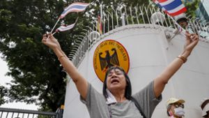 Eine Unterstützerin der thailändischen Monarchie schwenkt Nationalfähnchen vor der deutschen Botschaft. Foto: dpa/Gemunu Amarasinghe