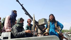 Schwer bewaffnete Taliban-Kämpfer fahren in einem Fahrzeug durch Mehtarlam, die Hauptstadt der Provinz Laghman in Afghanistan. Foto: dpa/Str