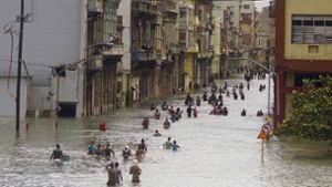 In Kubas Hauptstadt Havanna waten die Menschen durch überflutete Straßen. Foto: AP