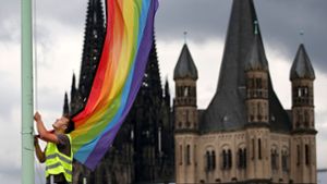 Auf Halbmast? Regenbogenfahne vor kirchlichem Hintergrund. Foto: dpa/Oliver Berg