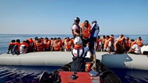 Rettungskräfte helfen vor der libyschen Küste Flüchtlingen aus einem Schlauchboot. Foto: AP