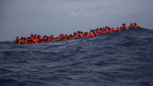 Migranten warten auf dem Mittelmeer darauf, von Helfern der NGO «Proactiva Open Arms» gerettet zu werden. Foto: AP