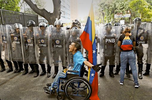 Ein Demonstrant beschimpft in Caracas Polizisten bei einer Demonstration für  den selbst ernannten Interimspräsidenten Guaidó. Foto: AP