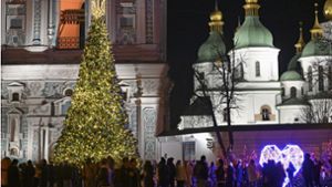 Menschen in Kiew versammeln sich am 23.12. um einen Weihnachtsbaum vor der Sophienkathedrale. Foto: dpa/Uncredited