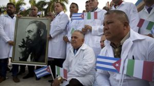 Bereit zum Abflug nach Italien: Kubanische Ärzte mit einem Bild von Fidel Castro. Foto: dpa