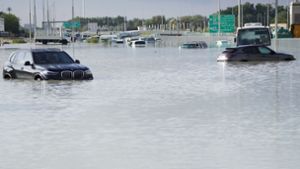 Fahrzeuge stehen verlassen im Hochwasser auf einer Hauptstraße in Dubai. Foto: Jon Gambrell/AP/dpa