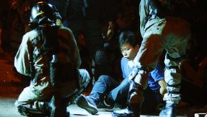 Polizisten verhaftet einen Aktivisten, der versucht hatte, aus der Polytechnischen Universität in Hongkong zu fli Foto: AFP/Michael Kappeler, dpa/Vincent Yu