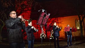 Vor der schön erleuchteten Peter- und Paulskirche spielt der Posaunenchor für das Videoprojekt „Köngener Weihnacht“. Foto: Ines Rudel