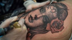 Eine Frau lässt sich auf der Internationalen Tattoo-Convention in Frankfurt am Main ein weibliches Gesicht in den Oberschenkel stechen. Foto: Boris Roessle