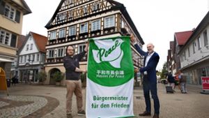 Der Kirchheimer Oberbürgermeister Pascal Bader (rechts) und der Rathaussprecher  Robert Berndt mit der Friedensflagge. Foto: /Horst Rudel