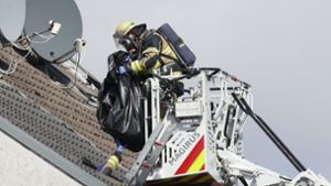 Für vier Menschen kam bei dem Brand in Solingen jede Hilfe zu spät. Hier birg ein Feuerwehrmann eine  Vermisste in einem Leichensack aus dem Haus. Foto: dpa
