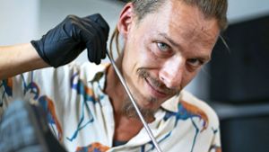 Mit unzähligen schnellen Bewegungen und mithilfe langer Stahlstäbchen sticht Clemens Fleig seinen Kunden verschiedenste Motive unter die Haut. Foto: Ines Rudel