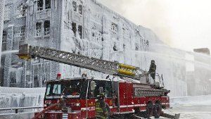 Chicagos Feuerwehr löscht einen Brand in einem Lagerhaus. Durch die Kälte gefriert das Löschwasser an der Fassade und verwandelt das Gebäude in einen Eispalast.  Foto: dpa