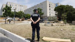 in Polizeibeamter steht in der Siedlung La Castellane, einem der Gebiete, die von den Drogenkartellen am Schlimmsten drangsaliert werden. Foto: AFP/Ludovic Marin