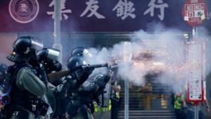 Polizisten mit Gasmasken schießen in Hongkong Tränengas auf Demonstranten. Foto: dpa