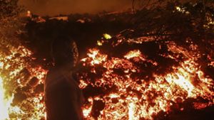 Eine Mann steht vor der Lava vom Ausbruch des Mount Nyiragongo in Buhene, am Stadtrand von Goma. Der kongolesische Berg Nyiragongo brach am 22. Mai  zum ersten Mal seit fast zwei Jahrzehnten aus. Foto: Justin Kabumba/AP/dpa