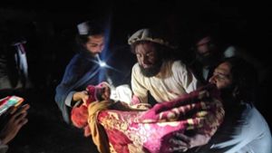 Afghanen bergen ein Opfer nach einem heftigen Erdbeben an der afghanisch-pakistanischen Grenzregion. Foto: dpa/Uncredited