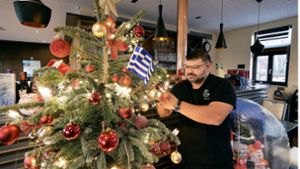 Dimitrios Evangelopoulos hat den Baum in der Gaststätte des TSV Weilimdorf schon geschmückt. Jetzt freut er sich an Heiligabend auf viele Gäste, die sonst alleine wären. Foto: Simon Granville/Simon Granville