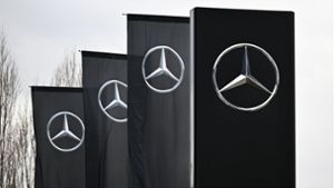 Das Logo der Automarke Mercedes-Benz ist weht an Fahnen. Der Autobauer will bis zu 3 Milliarden Euro weitere eigene Aktien am Markt erwerben. Foto: dpa/Bernd Weißbrod