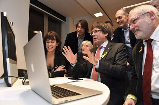 Der frühere Chef der katalanischen Regionalregierung, Carles Puigdemont (Mitte), sieht sich am Donnerstagabend im Square Meeting Center in Brüssel (Belgien) die Prognosen zur Regionalwahl in Katalonien an. Foto: AP