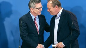 Innenminister Thomas de Maiziere (CDU, links) und Verdi-Chef Frank Bsirske reichen sich nach erfolgreichem Tarifabschluss die Hand.  Foto: dpa-Zentralbild