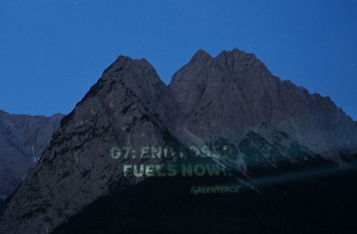 An die Waxensteine projiziert Greenpeace die Forderung „G7: End Fossil Fuels Now“. Foto: dpa/Angelika Warmuth