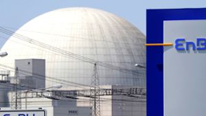 Hinter einem EnBW Logo ist das Kernkraftwerk Philippsburg  zu sehen Foto: dpa