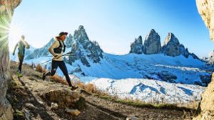 Laura Dahlmeier läuft beim Alpfronttrail durch die Dolomiten vor dem herrlichen Panorama der Drei Zinnen. Foto: Harald Wisthaler