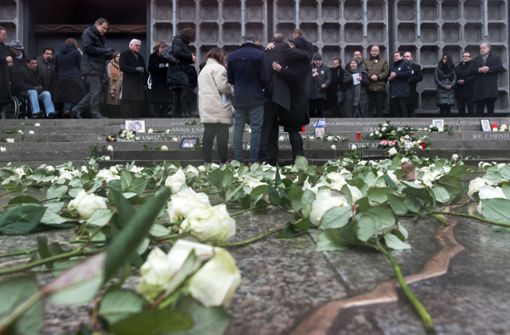 Angehörige legen bei der Einweihung der Gedenkstätte mit einem aus Bronze nachempfundenen Riss im Boden an der Gedächtniskirche auf dem Breitscheidplatz in Berlin Kerzen nieder und umarmen einander. Foto: dpa