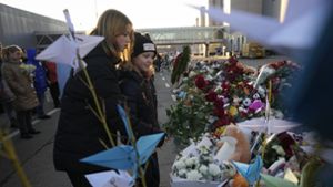 Nach dem Anschlag in Moskau:  Menschen legen Blumen an einer  Gedenkstätte vor der Crocus City Hall nieder Foto: dpa/Alexander Zemlianichenko