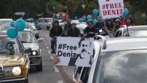 „Free Deniz“ steht auf einem Plakat, welches ein Beifahrer aus dem Autofenster hält. Foto: dpa