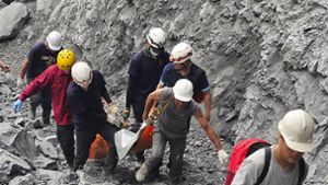 Feuerwehrleute und Steinbrucharbeiter bergen einen Tag nach dem Erdbeben eine Leiche aus dem Steinbruch Ho Ren. Foto: dpa/Agentur Voller Ernst
