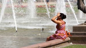 Eine Frau kühlt sich in Mannheim in einem Brunnen ab. Foto: imago/Ralph Peters/Ralph Peters