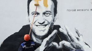 Ein Mitarbeiter des russischen Stromanbieters Rosseti entfernt ein Gemälde an einem Trafohäuschen in Sankt Petersburg, das den Oppositionellen Alexej Nawalny zeigt. Foto: imago images/Alexander Demianchuk