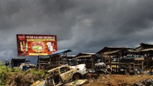 Werbetafeln vor Kriegskulisse: ein von Rebellen zerstörter Markt im Westen Kameruns. Foto: AFP/Marco Longari