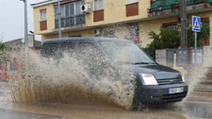 Ein Auto fährt durch aufgestautes Wasser in einer Straße in Villamanta, Madrid. Foto: dpa/Gustavo Valiente