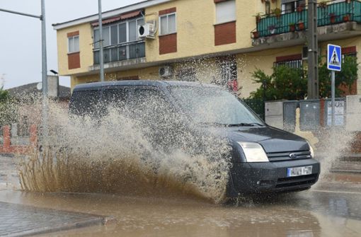 Ein Auto fährt durch aufgestautes Wasser in einer Straße in Villamanta, Madrid. Foto: dpa/Gustavo Valiente
