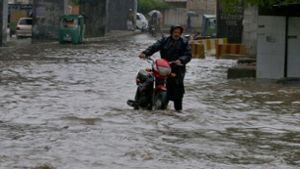 Starke Regenfälle haben die Straßen im pakistanischen Peschawar überschwemmt. In Pakistan sind bei für diese Jahreszeit ungewöhnlich starken Regenfällen mehrere Menschen ums Leben gekommen. Foto: Muhammad Sajjad/AP/dpa