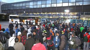 Flüchtlinge stehen vor dem Bahnhof in Mannheim. Foto: dpa