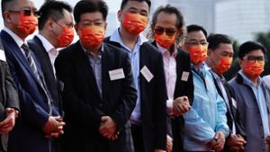 Mitglieder des Pro-Peking-Lagers tragen rote Mund-Nasen-Bedeckungen für die Treue zur Kommunistischen Partei. Foto: dpa/Liau Chung-Ren