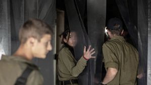 Israelische Soldatinnen und Soldaten besichtigen eine zerstörte Einrichtung im Kibbuz Nir Oz, eine der israelischen Gemeinden, die am 7. Oktober von der Hamas angegriffen wurden. Foto: Ilia Yefimovich/dpa