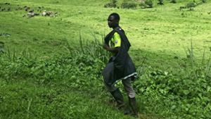 Ob dieser Mann in Gummistiefeln wohl zu den Kühen geht, die auf im Hochland nahe des Lake Buyonyi weiden? Foto: Susanne Hamann