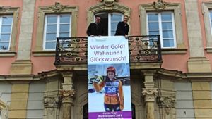 Joachim Bläse (links) und Klaus Arnholdt mit dem Glückwunschbanner am Rathausbalkon Foto: pr