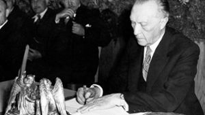 Konrad Adenauer, Präsident des Parlamentarischen Rates, unterzeichnet am 23. Mai 1949 das Grundgesetz. Foto: AP/HDG Bonn