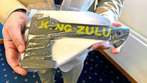 Ein Ermittler hält eine schwarze Axt mit der Aufschrift „King Zulu“ in den Händen. Sie gilt als Symbol für die kriminelle Black-Axe-Organisation. Foto: dpa/Britta Schultejans